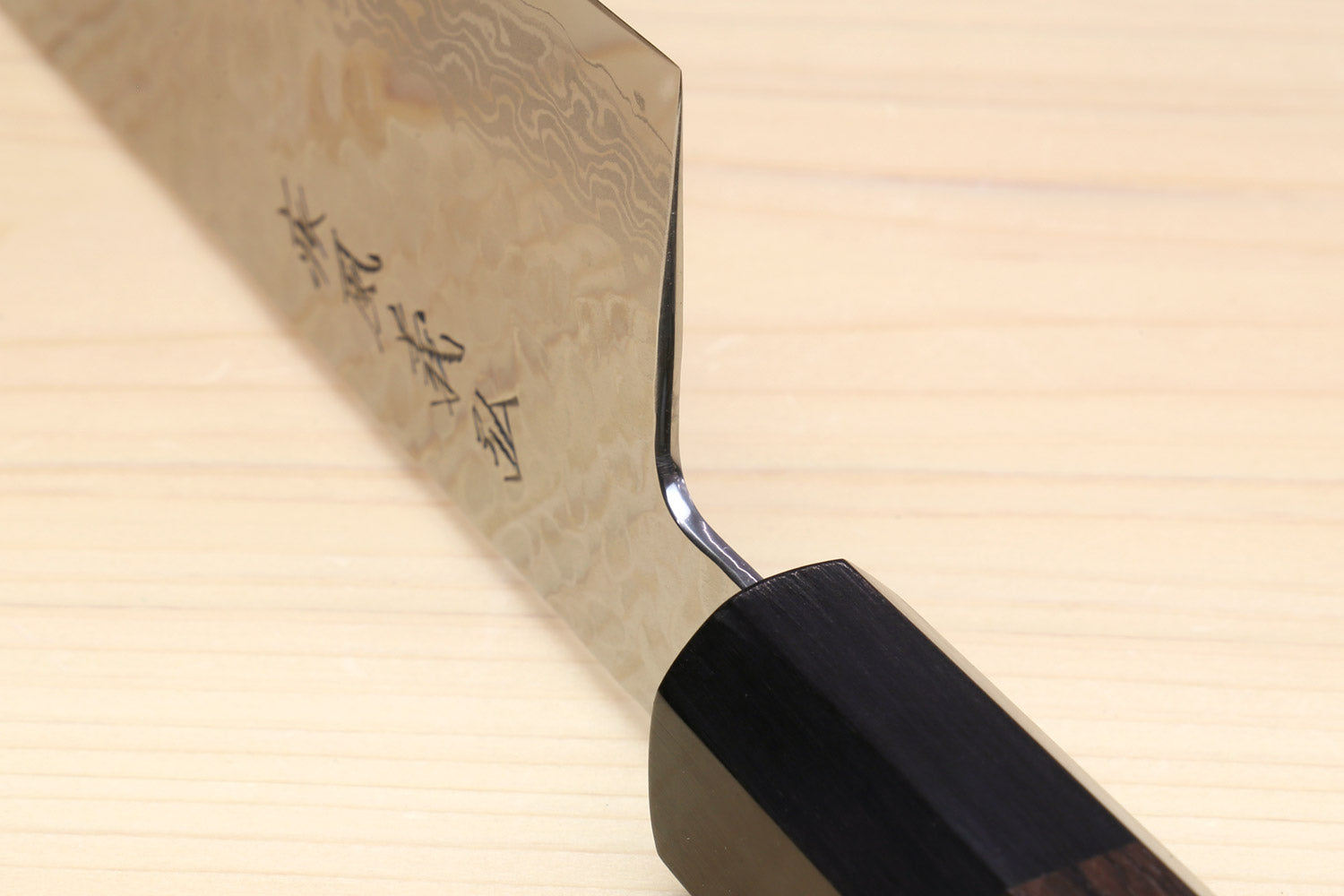 Kiritsuke chef knife heel and blade tip with hammered Damascus and dark handle
