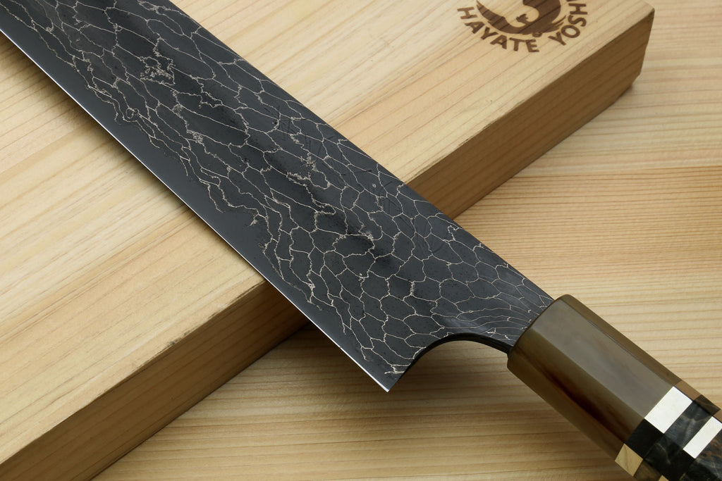 Sujihiki slicer knife with black snake-skin Damascus blade and dark handle on stand