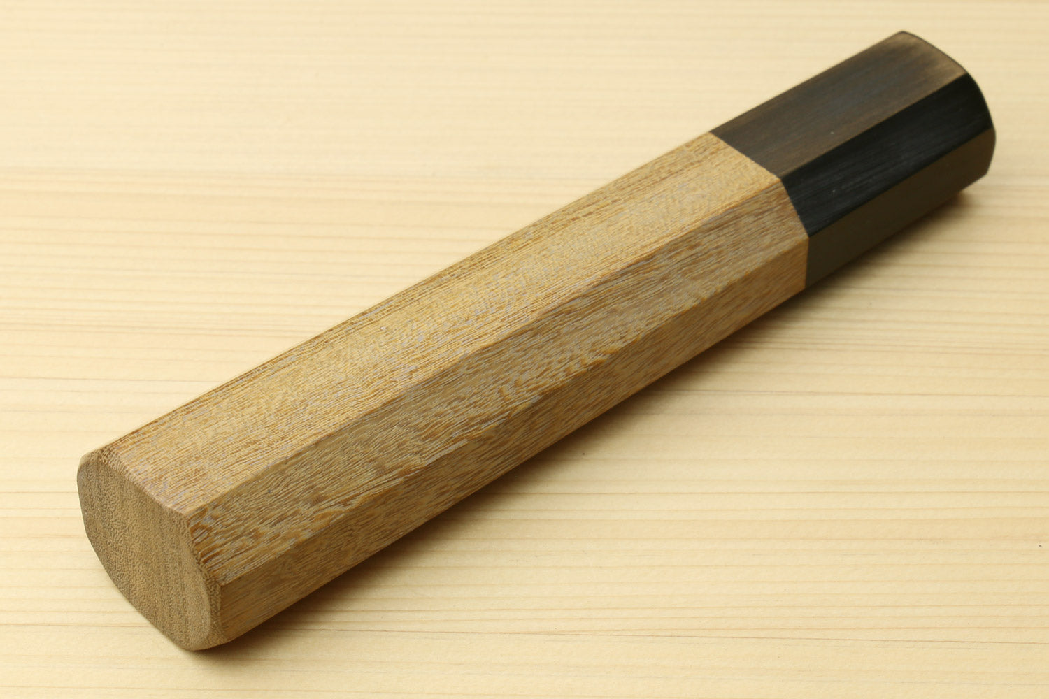 Ambrosia wood handle with dark ebony bolster sleeve and tapered grip, close-up