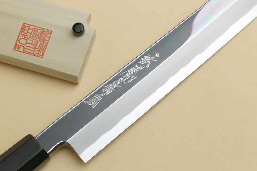 Japanese sushi sashimi knife close-up, mirror-polished blade with engraved markings
