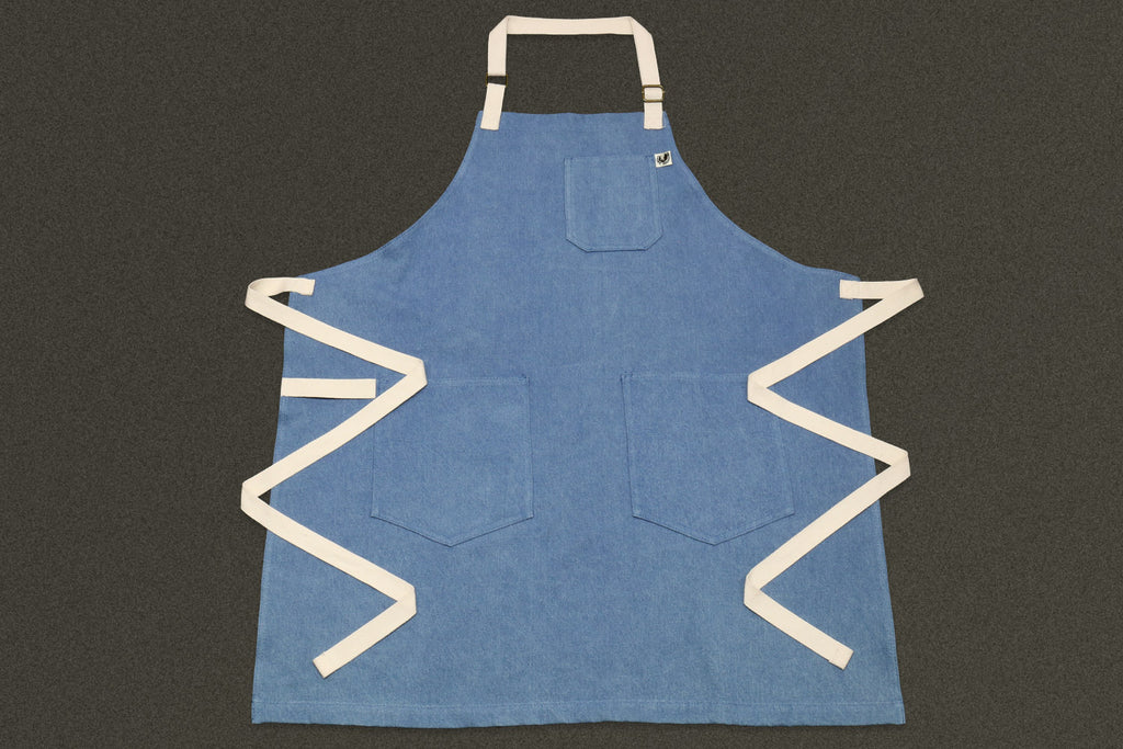 Light blue denim kitchen apron with square chest pocket and cream straps
