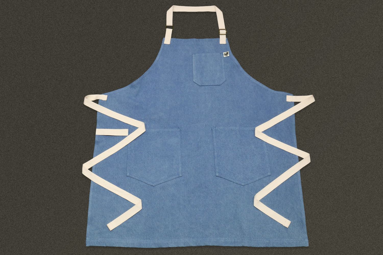 Light blue denim kitchen apron with square chest pocket and cream straps