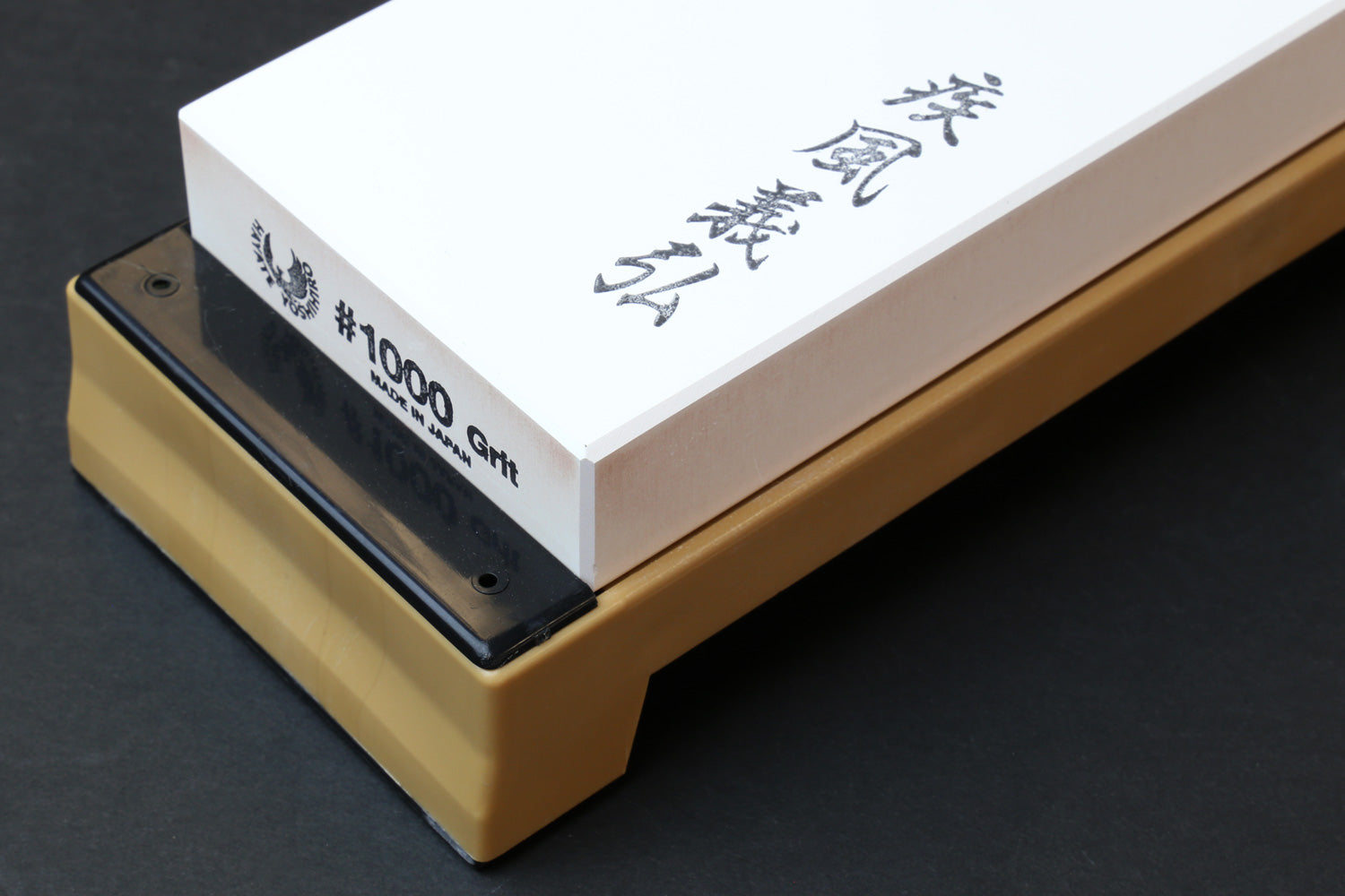 Sharpening whetstone 1000 grit with black side label and white top on wooden stand