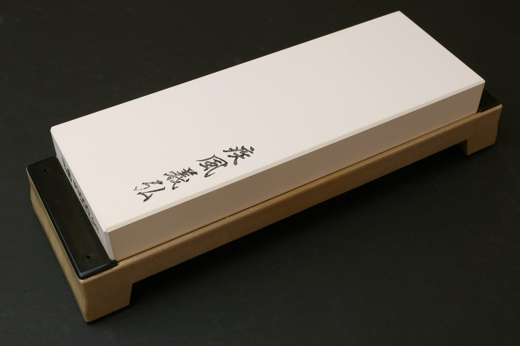 Sharpening whetstone 3000 grit white stone block on wooden holder, black backing
