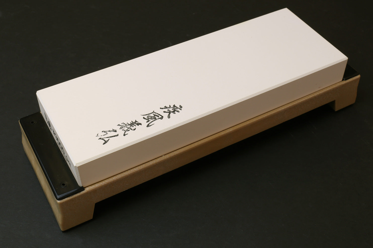 Sharpening whetstone 3000 grit white stone block on wooden holder, black backing