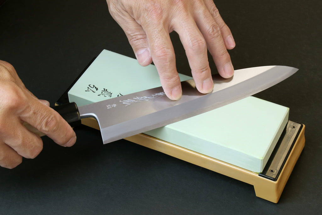 10,000-grit whetstone on base as a knife is sharpened