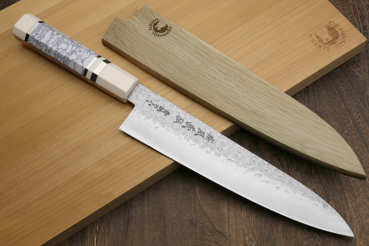 Gyuto chef knife with hammered stainless blade and white handle, ivory bolster