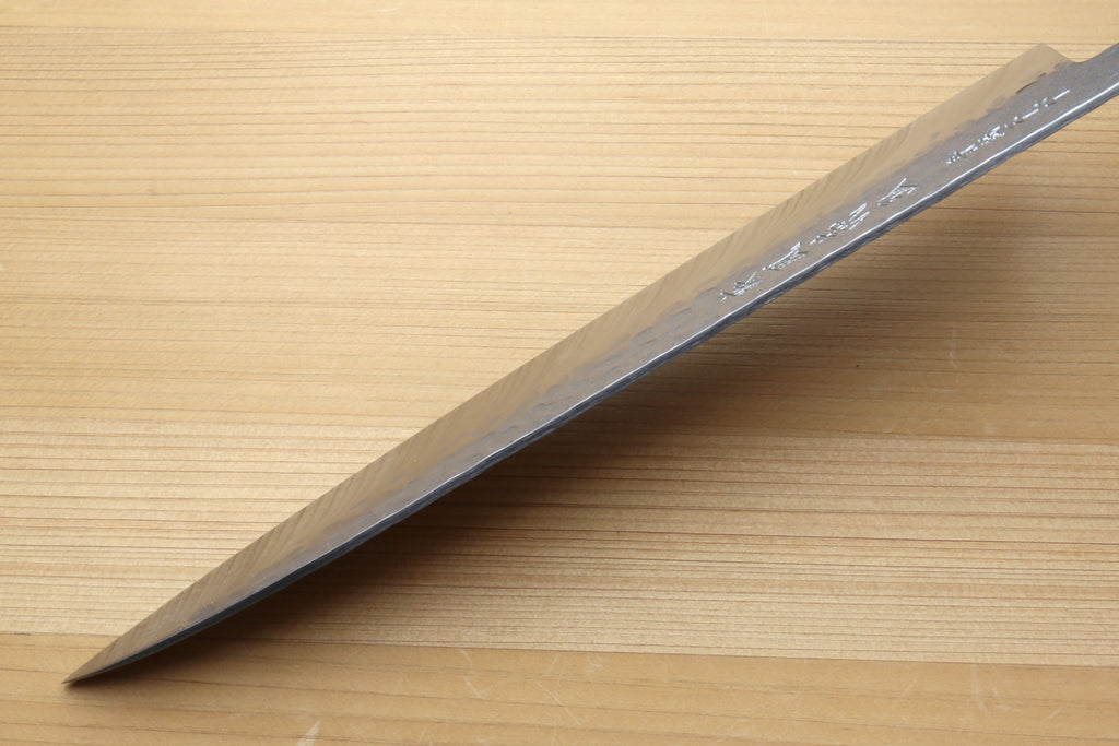 Gyuto chef knife side view with hammered stainless blade and sharpened tip