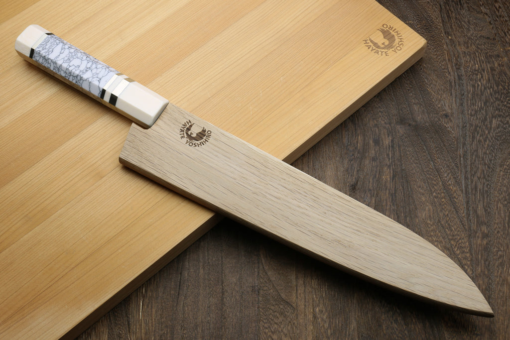 Gyuto chef knife with hammered stainless blade and white handle, ivory bolster