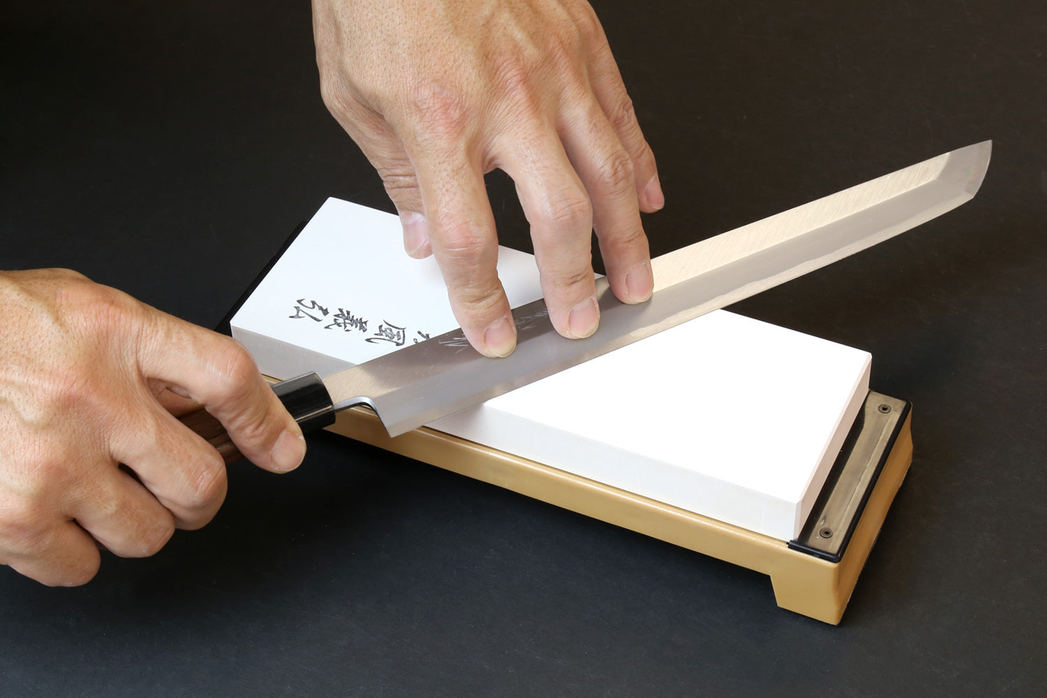 Hand sharpening on 6000 grit whetstone, white stone set in tan base