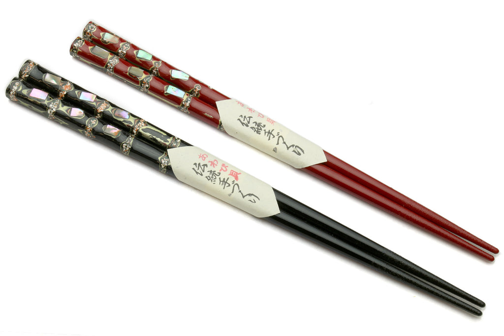 Pair of chopsticks with red and black lacquered finish, patterned caps