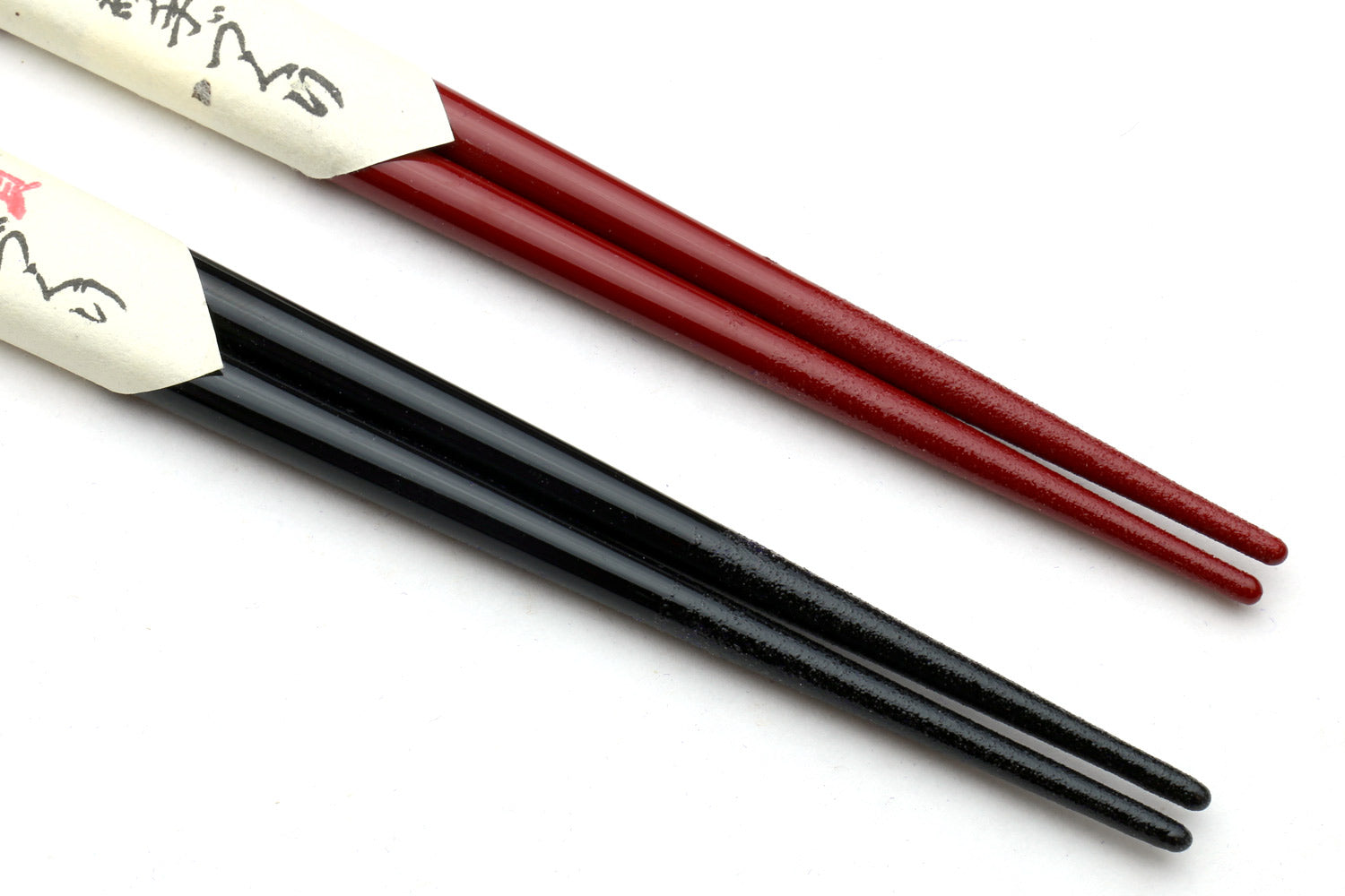 Red and black chopsticks, tapered ends with white label bands