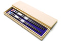 Lacquered chopsticks set in pale wood storage box, black shafts with blue and red accents