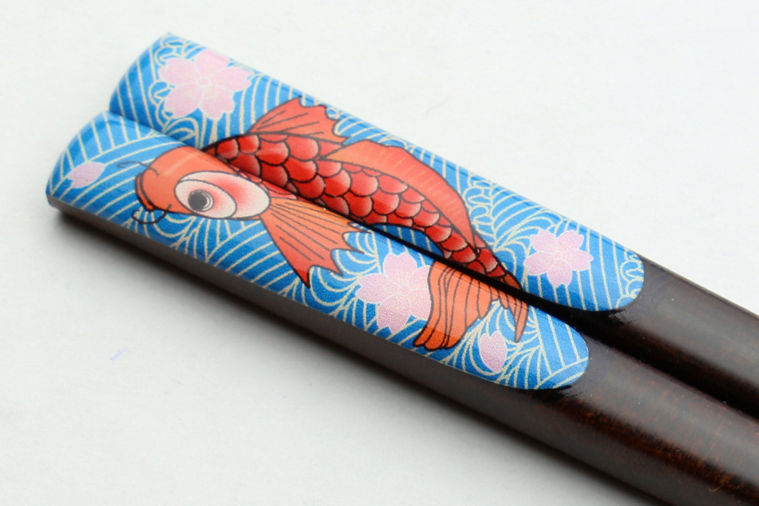 Pair of lacquered chopsticks with blue koi fish decorated grip and silver rings