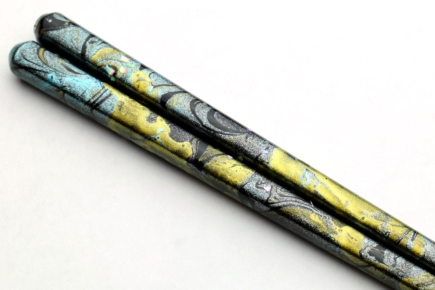 Pair of lacquered wooden chopsticks with blue-green marble design and gold flecks