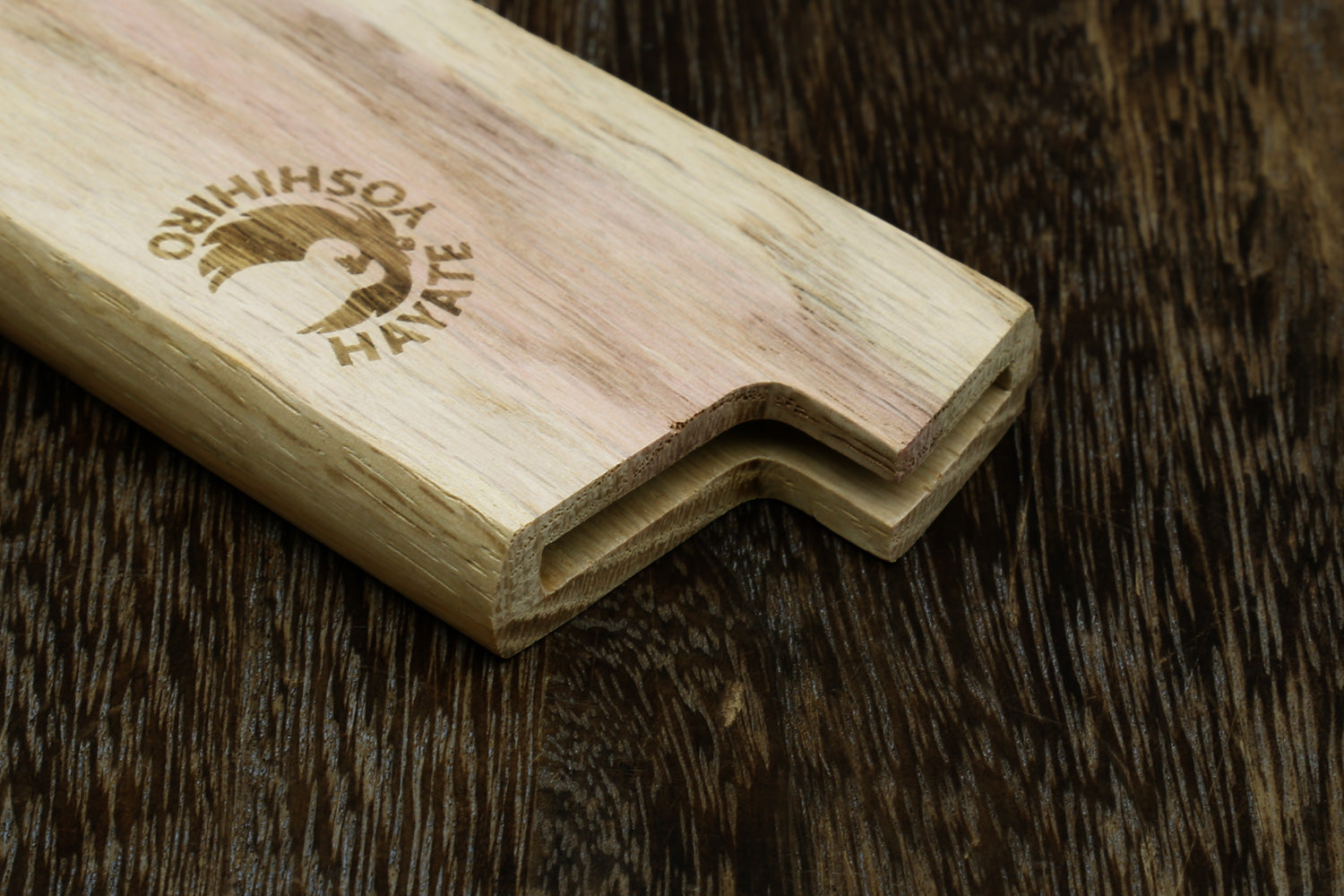 Light oak wooden saya blade protector close-up with logo and scalloped opening