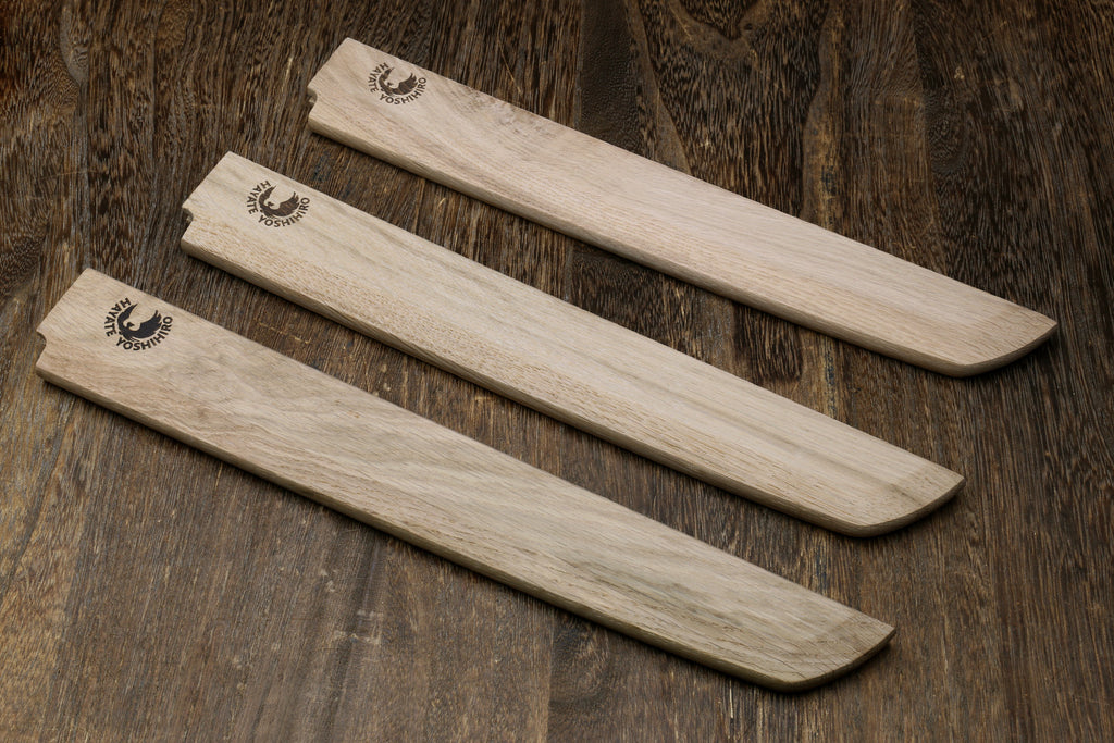Set of three light-wood saya covers with carved logos and tapered edges