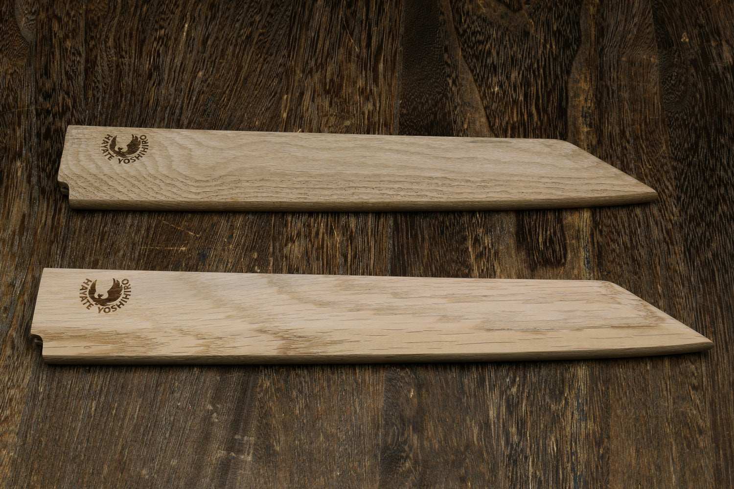 Pair of light oak wooden saya covers with brand emblems, side by side
