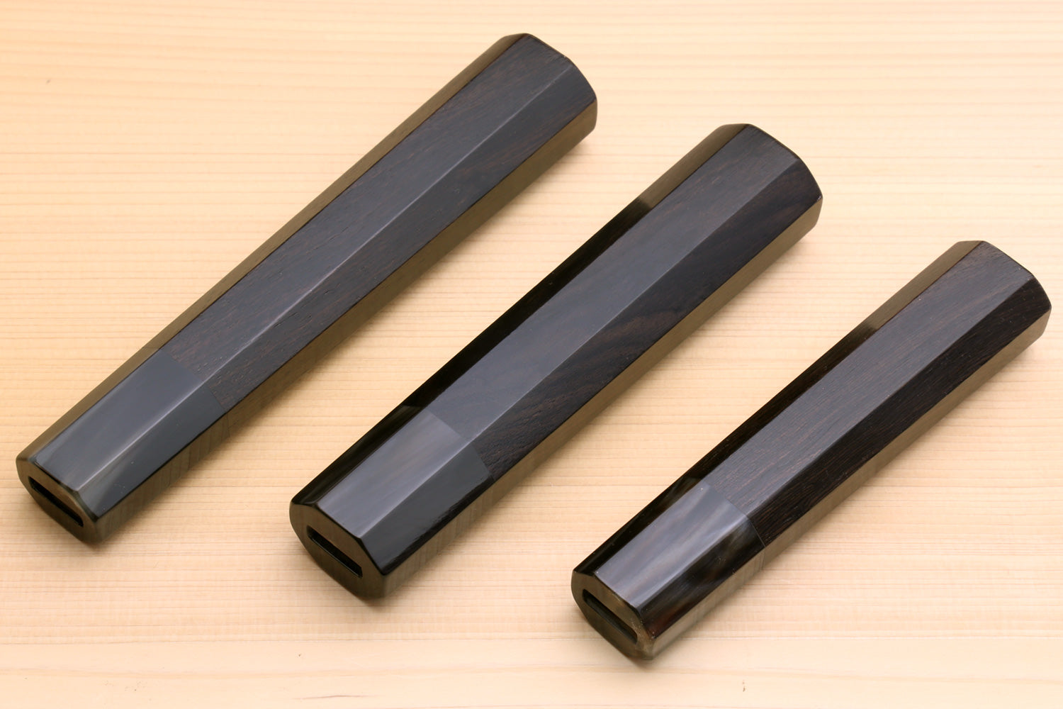 Four ebony knife handle blanks with dark horn bolsters, top view