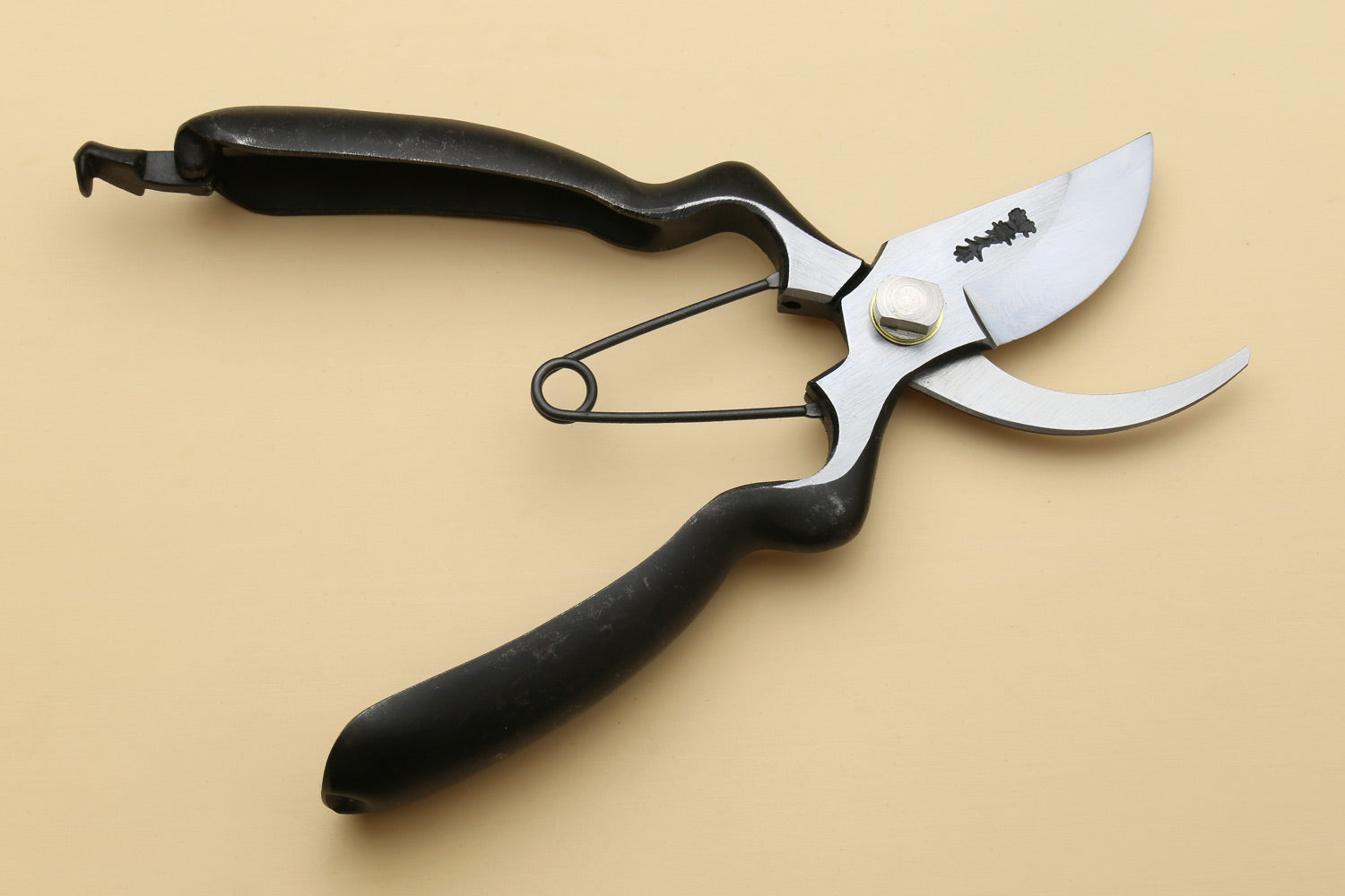 Pruning shears with white blades and black handles, curved cutting tip