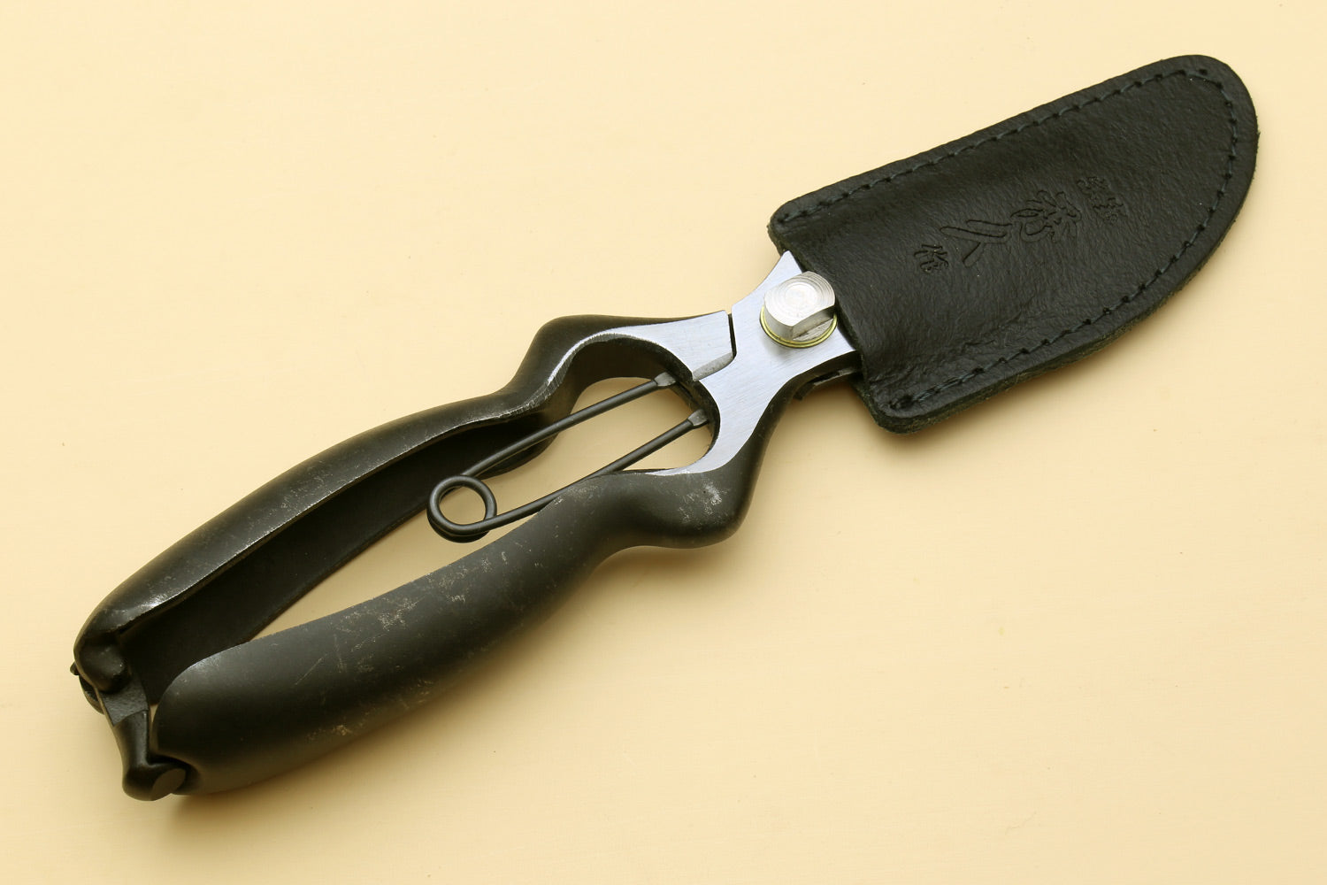 Black pruning shears with leather-style sheath and curved metal blades