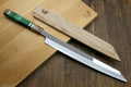 Japanese sushi knife with mirror-finished stainless blade and green-accent handle on board