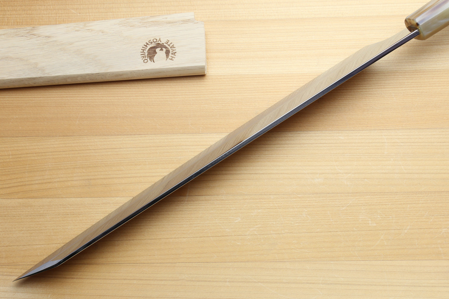 Japanese sushi knife with mirror-finished stainless blade and green-accent stabilized wood handle