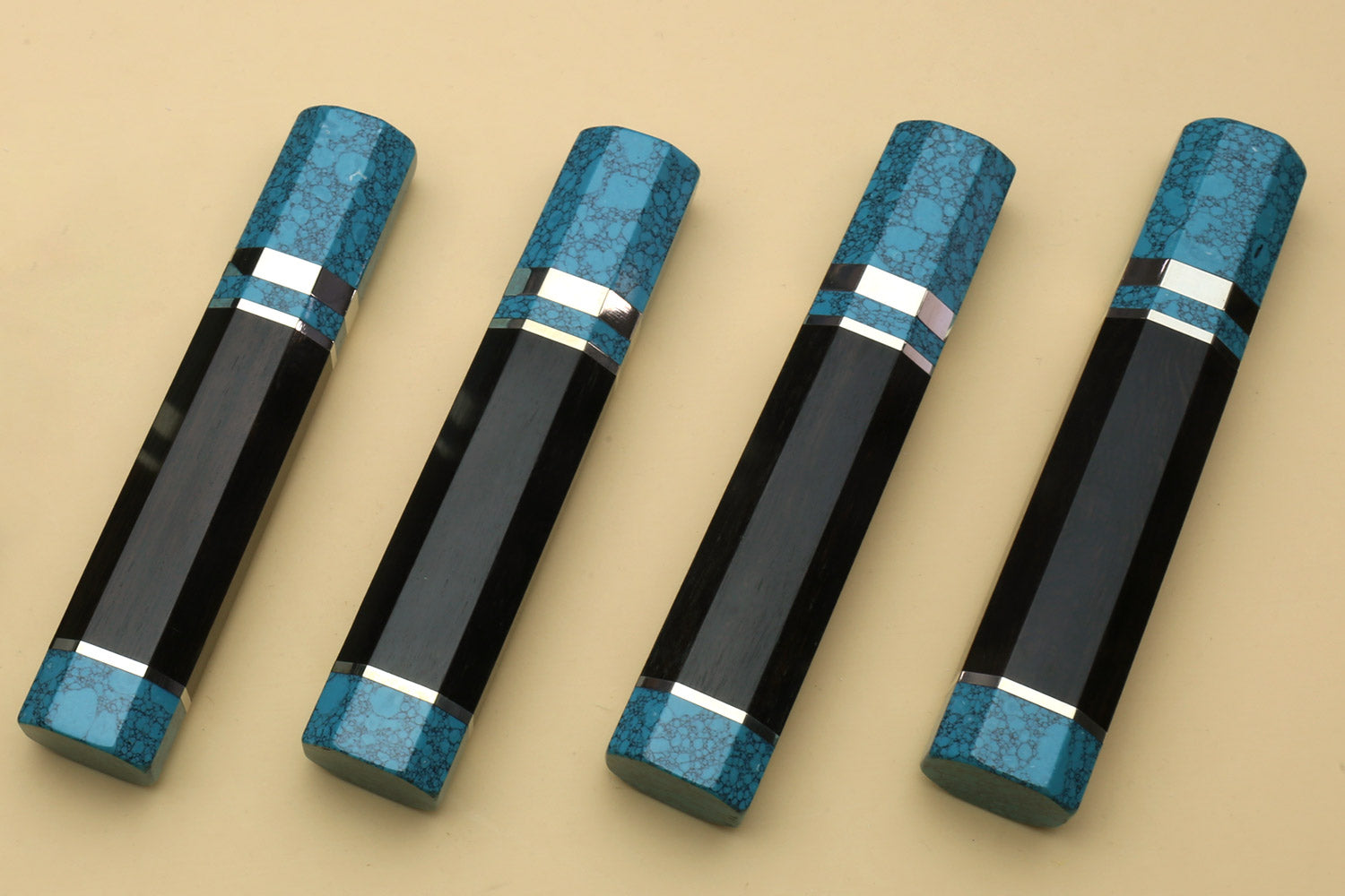 Set of four turquoise-blue knife handles with black cores and white stripes