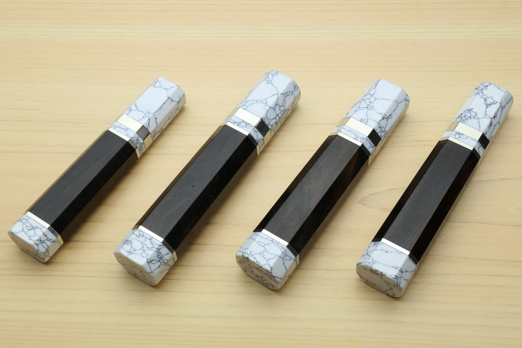 Ebony knife handles with white howlite bolsters and metal bands, top view