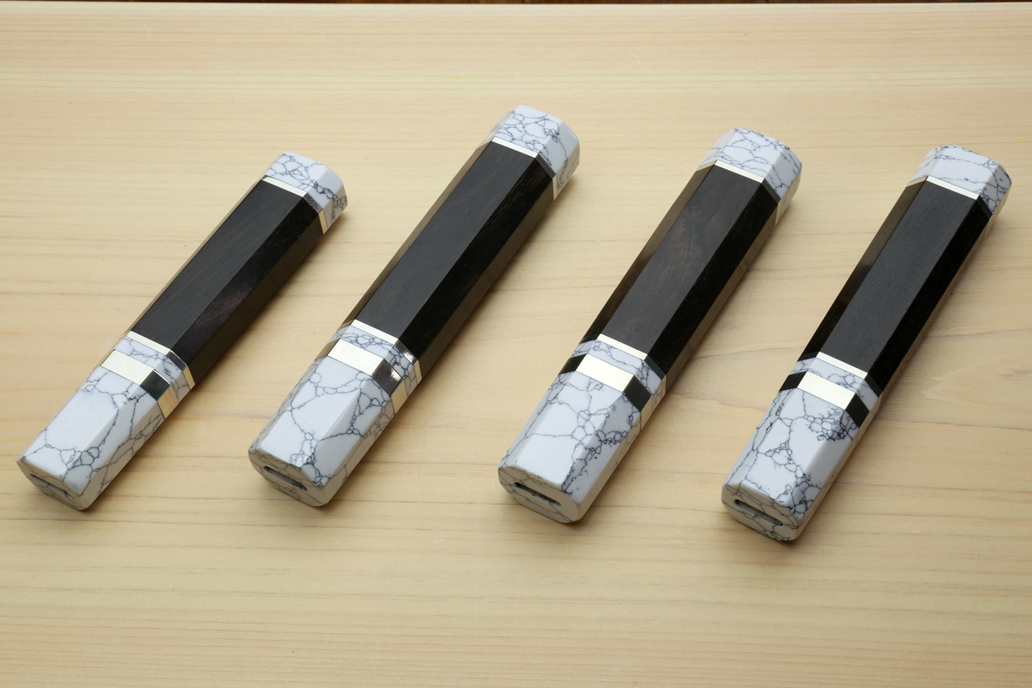 Ebony knife handles with white howlite bolsters and metal bands, set of four