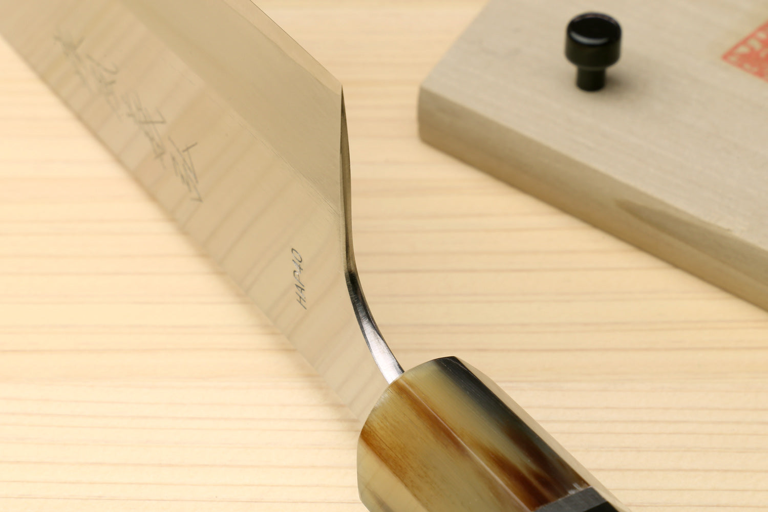Japanese chef knife with white steel blade edge and dark octagonal handle with triple rings