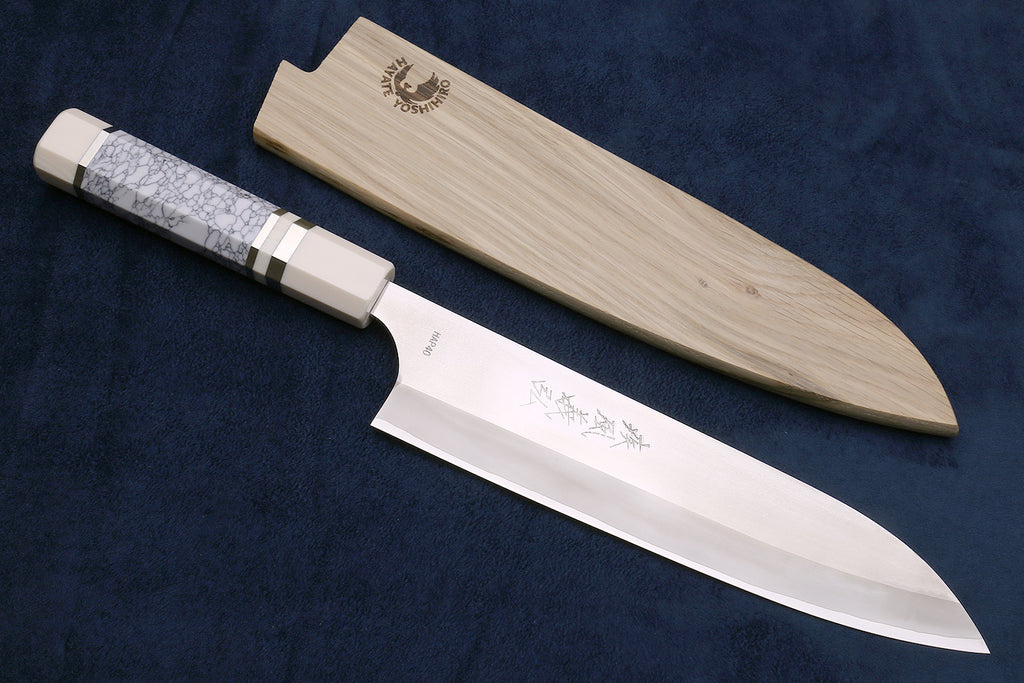 Chef's gyuto knife with white blade, ivory-pattern bolster, and engraved logo.