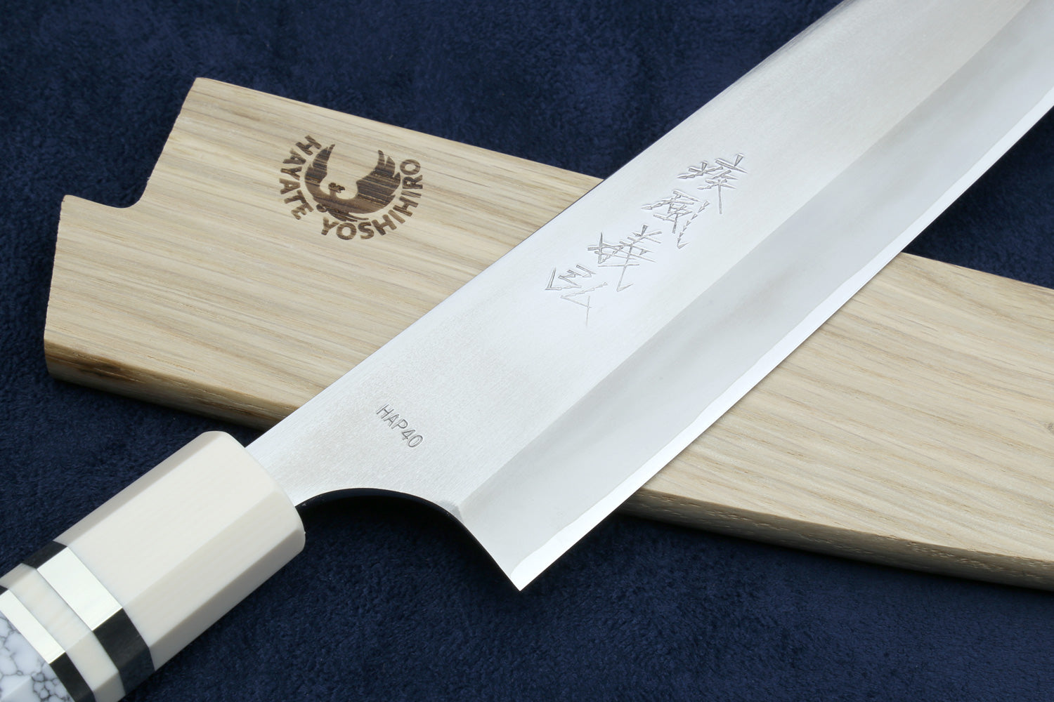Chef's gyuto knife blade with engraved markings and ivory-pattern bolster.