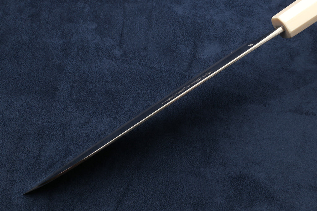 Chef's gyuto knife with pointed tip and ivory-pattern handle; side view.