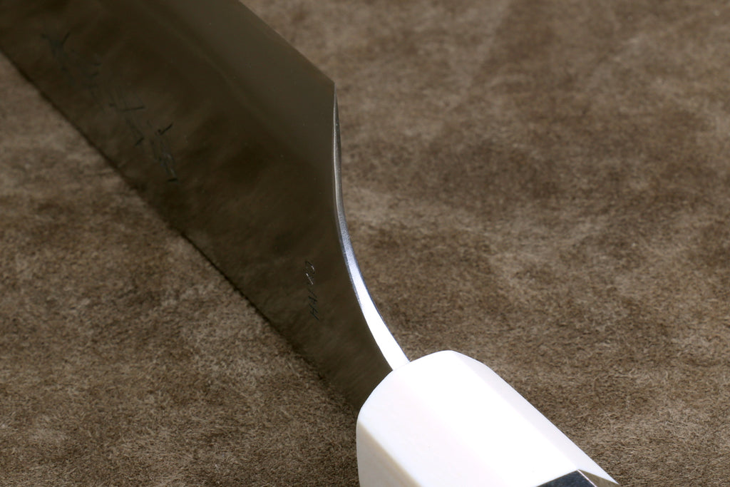 Gyuto chef knife heel detail, silver blade and octagonal ivory bolster with dark band