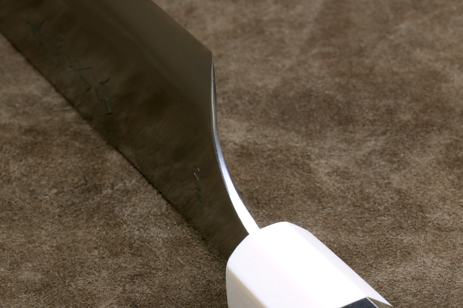 Gyuto chef knife heel detail, silver blade and octagonal ivory bolster with dark band