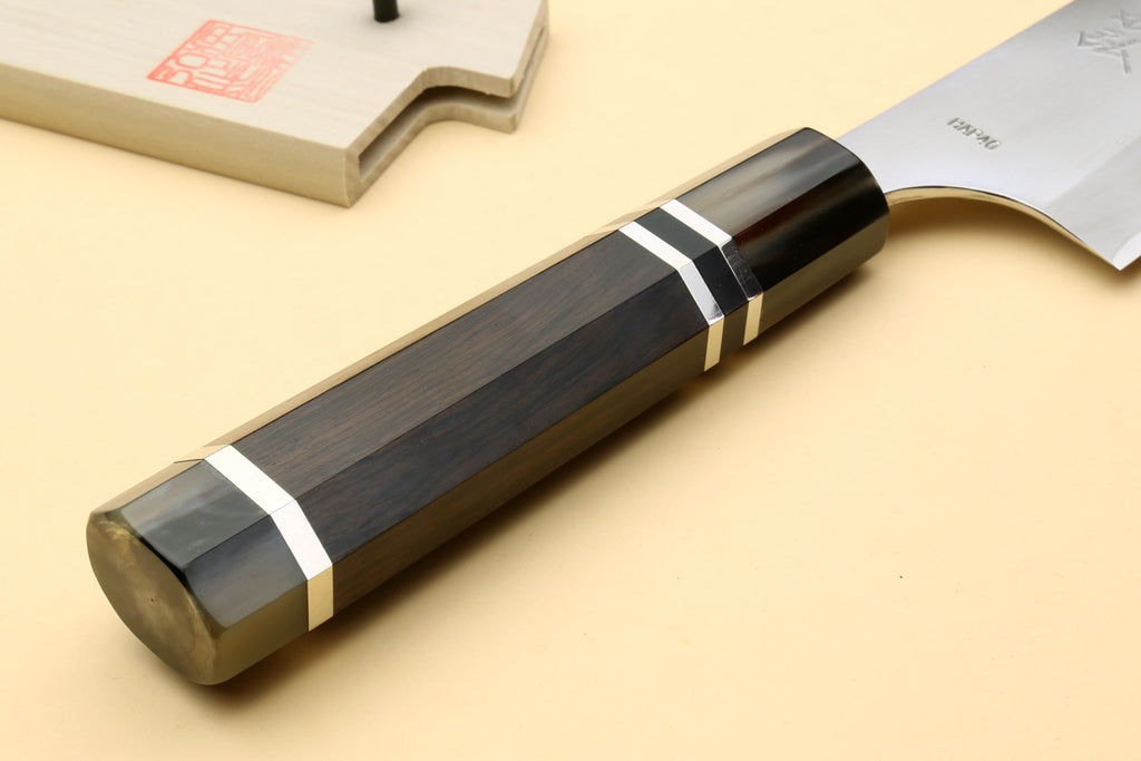 Chef knife showing dark ebony handle with triple silver rings
