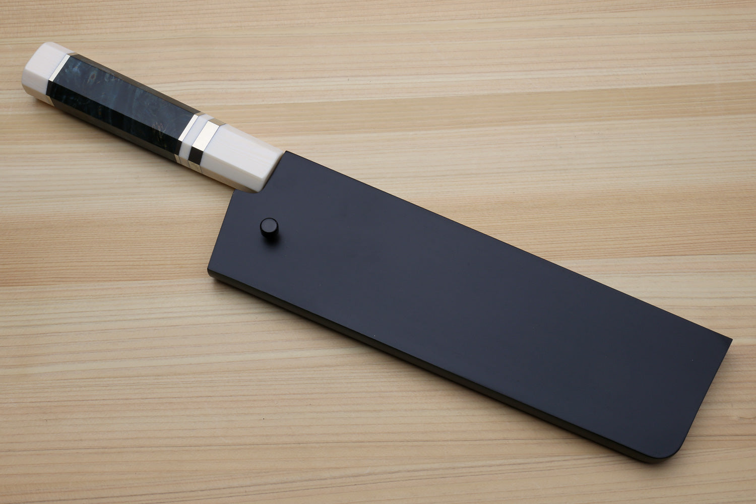 Nakiri vegetable chef knife with dark handle and black blade guard on display