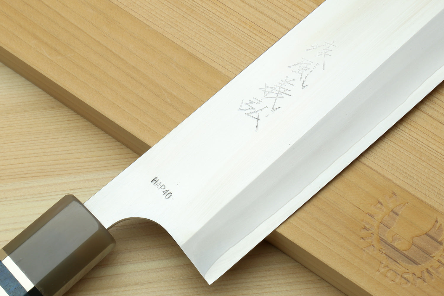 Nakiri knife blade close-up with engraved markings, with white magnolia saya