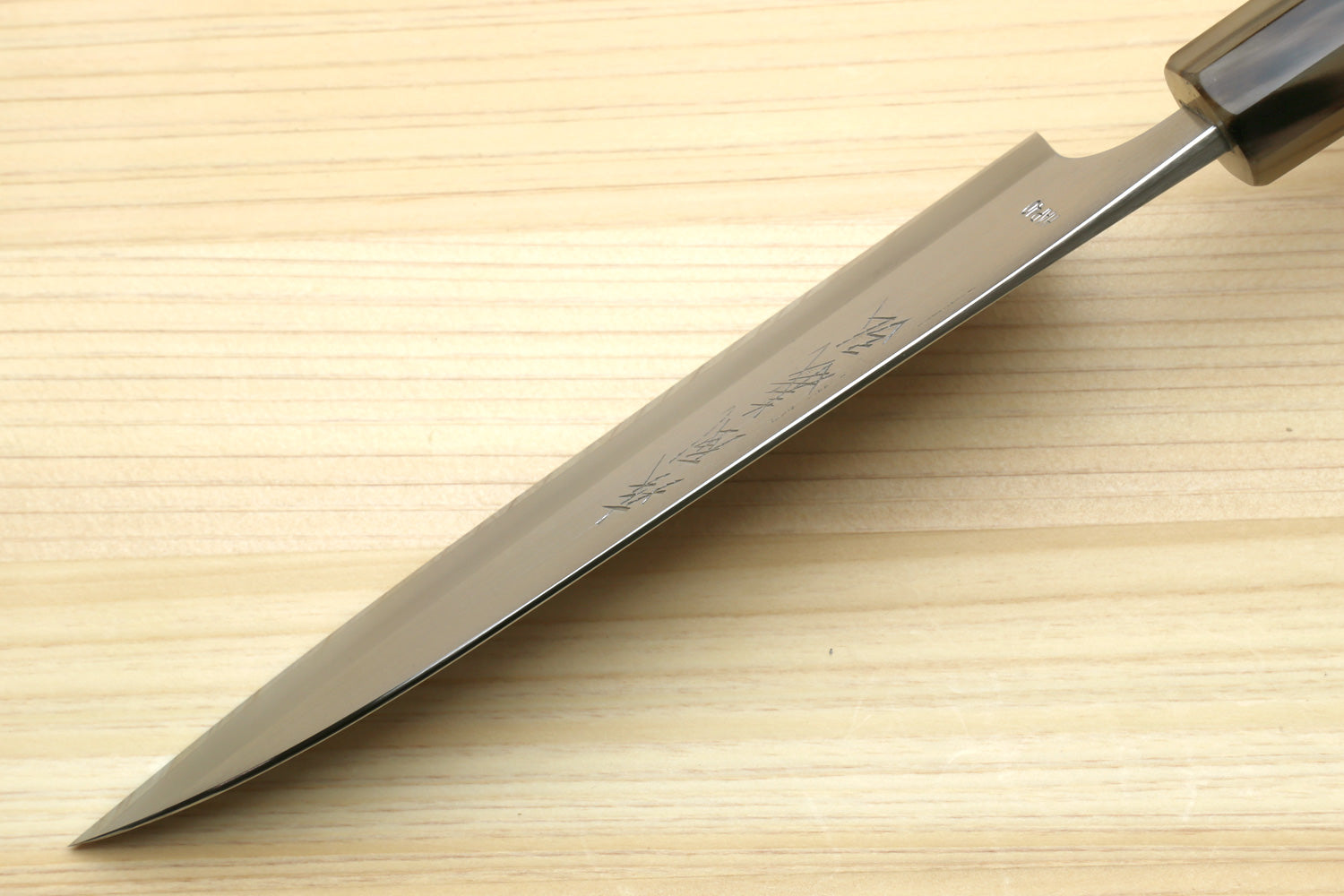 Petty chef knife side view with tapered blade and dark triple-ring handle
