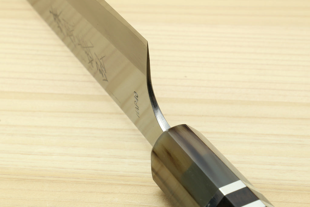 Petty chef knife bolster and edge close-up with dark handle and striped rings
