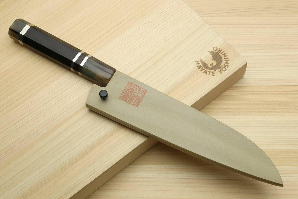 Petty chef knife on wooden board, showing dark handle and curved blade edge