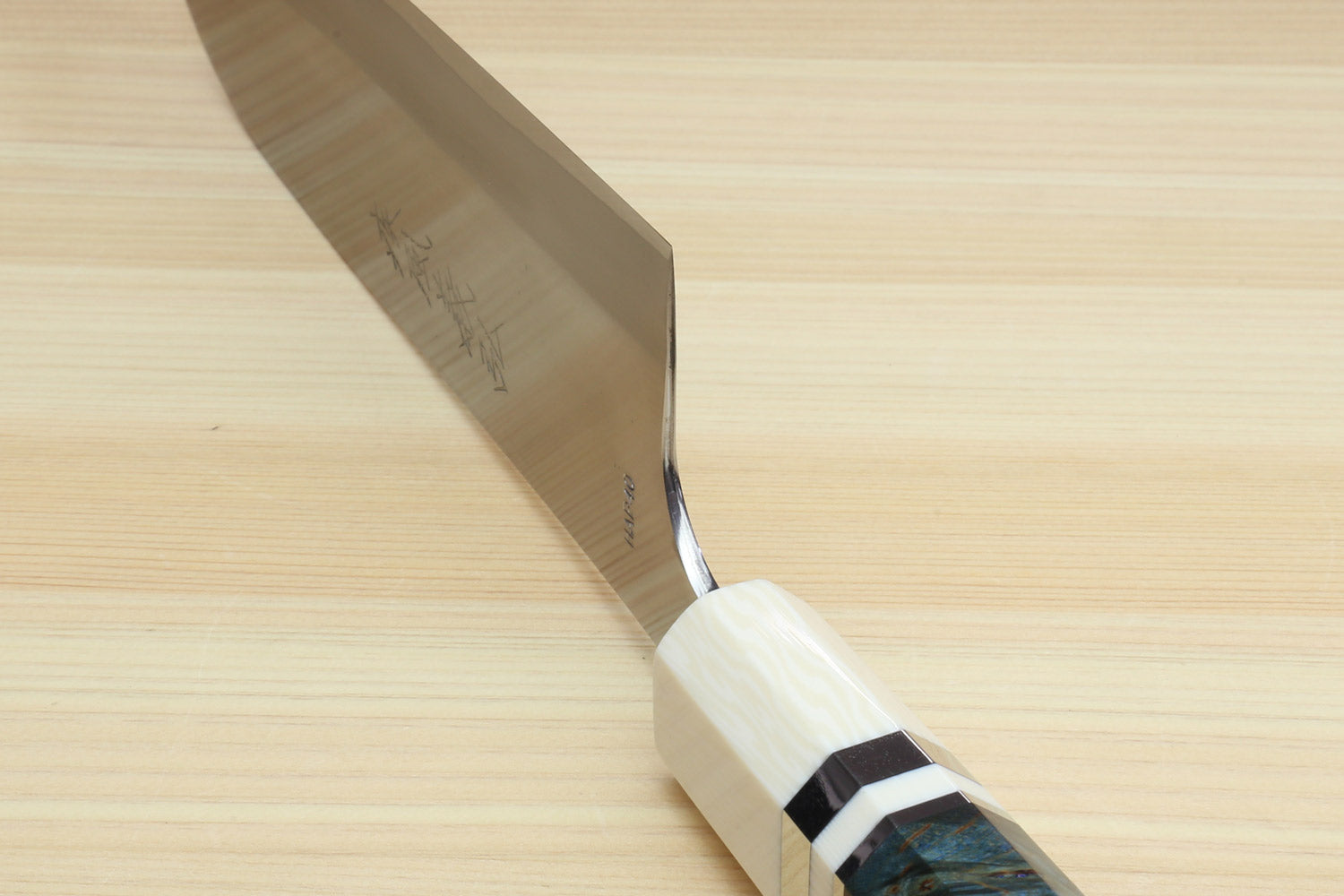 Santoku chef's knife blade edge and dark blue handle with ivory bolster