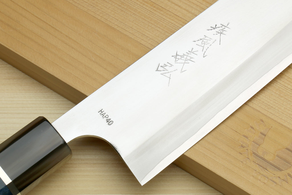 Santoku chef's knife showing stamped HAP40 mark on white blade and blue handle