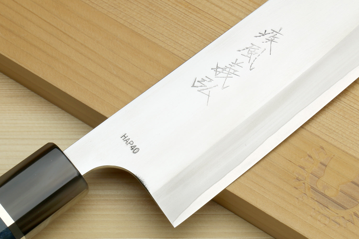 Santoku chef's knife showing stamped HAP40 mark on white blade and blue handle