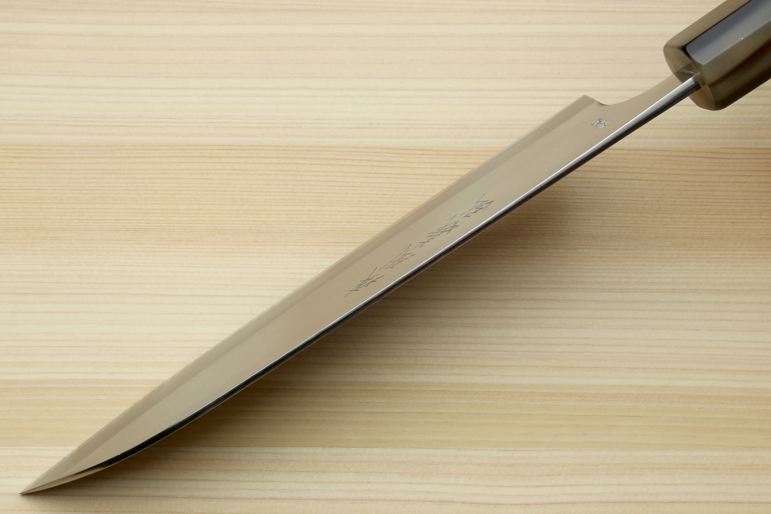 Santoku chef's knife close-up of pointed white blade with blue handle accents