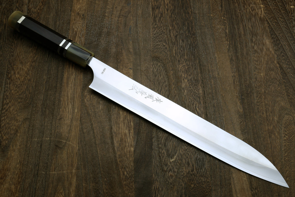 Sujihiki slicer with dark ebony handle and engraved Japanese text on white blade