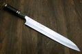 Sujihiki slicer with dark ebony handle and engraved Japanese text on white blade