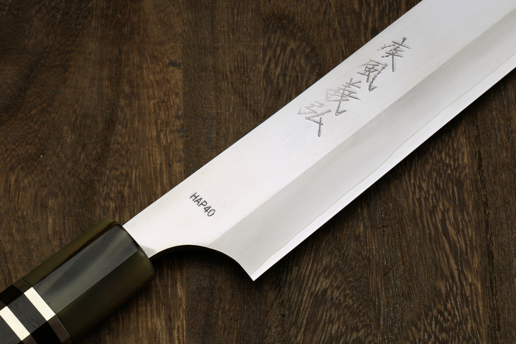 HAP40 sujihiki slicer blade with Japanese markings and dark handle, side view
