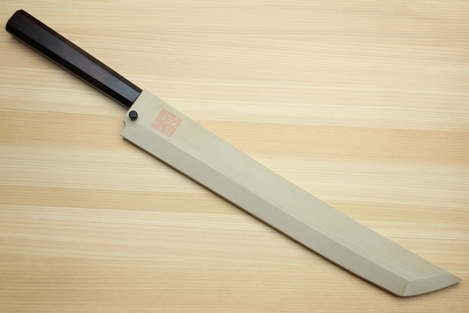 Japanese knife with dark handle and light wooden saya; mirror-finished blade shown.